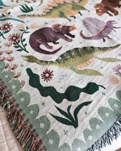 a blanket with dinosaurs and flowers on it