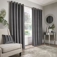 a living room filled with furniture and a large window covered in grey drapes next to a mirror