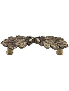 an image of a metal door handle with leaves on the front and back ends in bronze