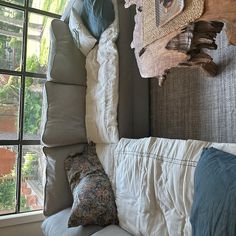 a white couch sitting next to a window in a living room with pillows on top of it