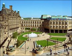 an aerial view of a courtyard with fountain and buildings in the background