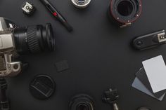 a table topped with lots of different types of cameras and accessories on top of it