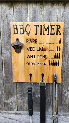 a bbq timer sign on the side of a wooden fence next to two umbrellas