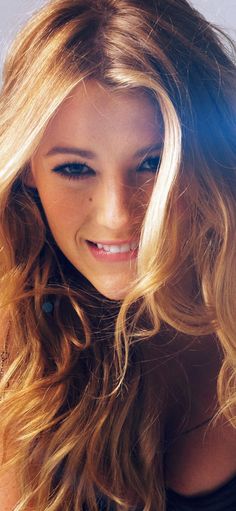 a close up of a person with long hair and a cell phone in her hand