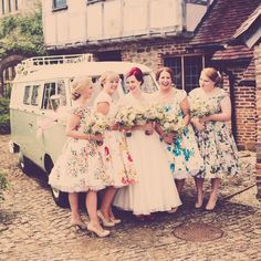 a group of women standing next to each other in front of a white vw van