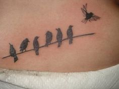 a woman's stomach with birds sitting on a wire and the word love written in black ink