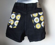 Up Cycled Black Twill Wrangler Cut Off Shorts with Yellow Floral Appliques I shortened these shorts and stitched in a raw hem. I ironed in a 1 inch cuff but they could be worn uncuffed. I added floral fabric patches to the coin pocket and to the back pockets. Front pockets are functional while the back pockets are sewn shut. Up Cycled Wrangler High Rise black twill cut off shorts with raw hem Zipper front Rise 13 inches 4 inch inseam (Cuffed) Waist flat is approximately 16 inches Hips flat is ap Spring Cutoff Shorts With Hip Pockets, Fitted Cotton Jean Shorts With Pockets, Retro Cotton Jean Shorts With Frayed Hem, Retro Black Cotton Bottoms, Retro Cotton Shorts With Frayed Hem, Vintage Black Bottoms For Summer, Cutoff Cotton Shorts With Hip Pockets, Fitted Cutoff Shorts With Pockets, Vintage Black Summer Bottoms