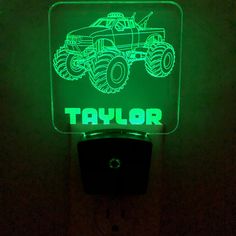 a green light up sign with a monster truck on it's front and the words taylor