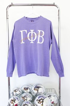 a purple shirt that says top with sequins in front of it on a rack