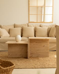 a white vase sitting on top of a wooden table in front of a beige couch