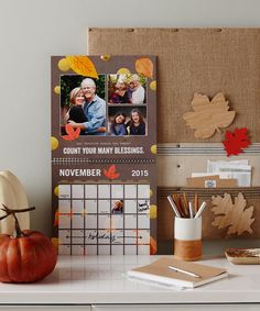 a desk with a calendar, pumpkin and other decorations