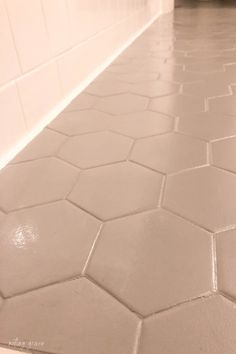 a white tiled floor in a bathroom next to a toilet