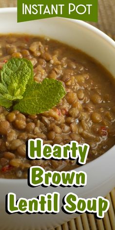 a white bowl filled with beans and mint on top of a wooden table next to a green leaf