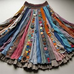 a multicolored skirt with buttons on the front and bottom is hanging up against a wall