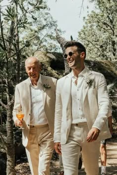 two men in white suits walking through the woods