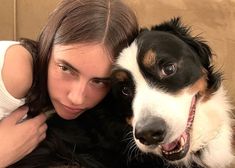 a woman is hugging her dog on the couch