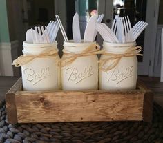 four mason jars with spoons and forks in them