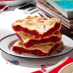 three pieces of pie sitting on top of a white plate next to a stack of books