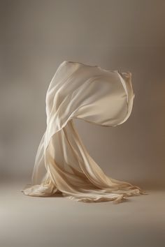 an image of a white cloth blowing in the wind on a gray background with soft lighting