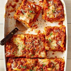 square lasagna casserole in a white dish with a spatula on the side