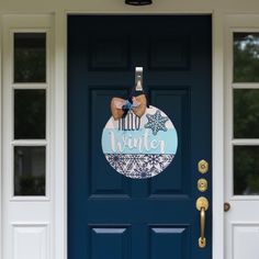 a blue door with a sign that says winter hanging on it's front door