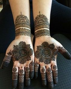 two hands with henna tattoos on them