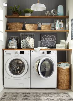 a washer and dryer sitting in front of a shelf with baskets on it