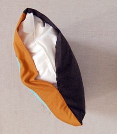 an orange, black and white hat is laying on the floor