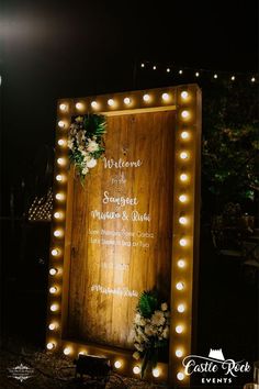 a wooden sign with lights around it