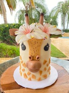 a cake decorated to look like a giraffe with flowers on it's head