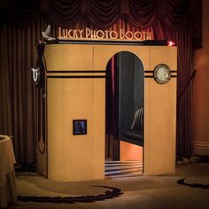 the lucky photo booth is lit up with neon lights and features a clock on it