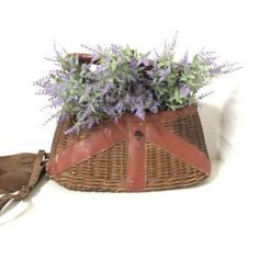 a wicker basket with purple flowers in it on a white background and an old pair of scissors