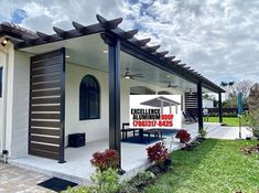 a white house with black trim and an awning on the roof that says excellence aluminum roof