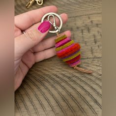 a hand holding a keychain that has been made out of yarn