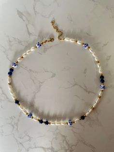 This pearl necklace screams summer to me, with waterproof and tarnish-resistant gold beads, blue flower-printed porcelain ceramic beads, and stunning lapis lazuli. Wear this natural gemstone pearl necklace alone, or stacked with your favourite necklaces, falling at 16 inches, it sits around your neck/ above your collar bone.  The extenders, clasps and beads are all PVD coated, which means you need not fear this necklace tarnishing after a dip in the pool. Lapis Lazuli is a wonderful healing ston Pearl And Beaded Necklace, Bead Necklace Stack, Necklace Natural Stones, Blue Beaded Necklace With Pearls, Blue Stone Jewellery, Elegant Beaded Jewelry, Pearl And Bead Necklace, Blue Pearl Necklace, Gold Pearl Necklace With Colorful Beads