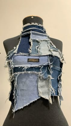 a mannequin made out of old jeans with patches and fraying on it