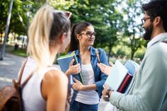 group of students talking to each other in the park - stock photo -'s