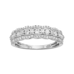 a white gold wedding band with round cut diamonds on the top and bottom, set in 18k white gold