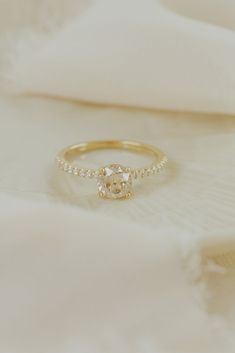 a diamond ring sitting on top of a white cloth