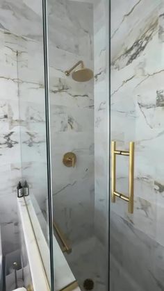 a walk in shower sitting next to a white sink under a faucet mounted on a wall