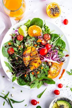 a salad with oranges, onions and spinach in it on a white plate