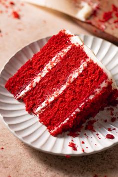 a slice of red velvet cake on a paper plate