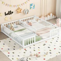 two baby cribs in a room with toys on the floor and decorations around them