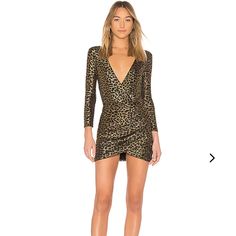 a woman in a leopard print mini dress with long sleeves and thigh high heels standing on a white background