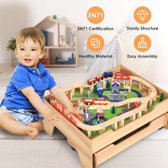 a young boy playing with a wooden train set on the floor in front of him