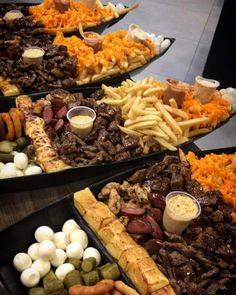 several trays filled with different types of food including meat, cheese and other foods