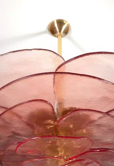 a close up of a flower shaped object on a white surface with a light fixture in the background