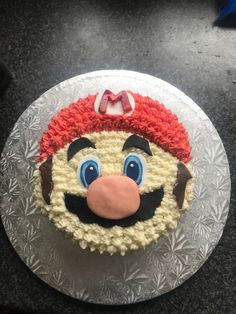 a cake that looks like mario from mario kart on top of a silver plate