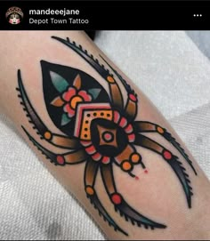 a tattoo on the arm of a person with an intricate spider and geometric shapes around it