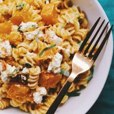 a white plate topped with pasta and cheese